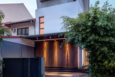Modelo de fachada de casa multicolor actual de tres plantas con revestimientos combinados y tejado de un solo tendido