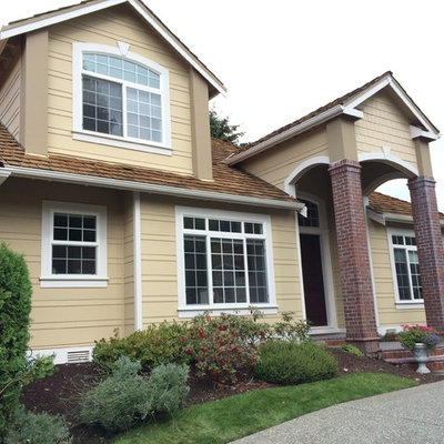 Mid-sized traditional beige two-story vinyl exterior home idea in Seattle with a hip roof