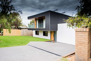 На фото: большой, двухэтажный, черный частный загородный дом в современном стиле с облицовкой из металла, плоской крышей и металлической крышей с