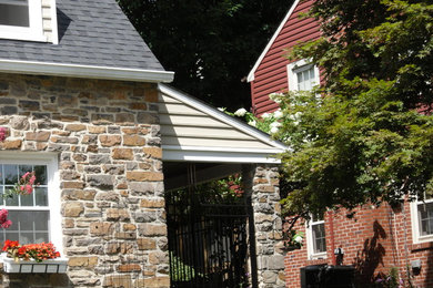 Ejemplo de fachada de casa marrón de estilo americano de tamaño medio de dos plantas con revestimiento de piedra, tejado a dos aguas y tejado de teja de madera