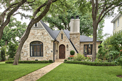 Example of a classic beige one-story stone exterior home design in Austin with a shingle roof