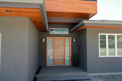 Mid-sized minimalist gray two-story stucco exterior home photo in Vancouver with a mixed material roof