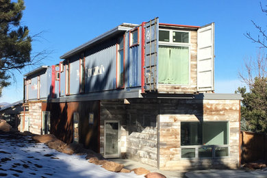 Foto della facciata di una casa piccola multicolore moderna a due piani con rivestimento in legno, tetto piano e copertura mista