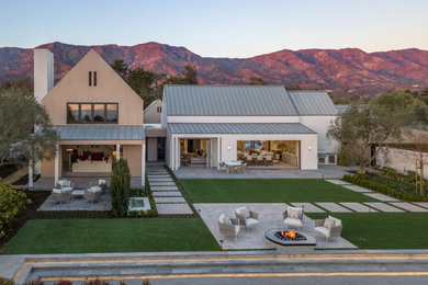 Cottage white two-story exterior home idea in Santa Barbara with a metal roof