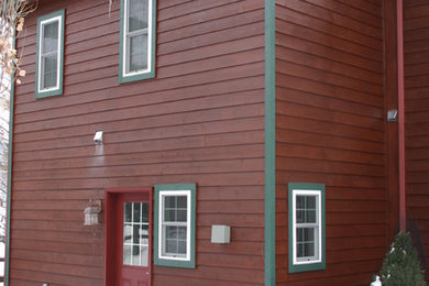 Diseño de fachada de casa roja tradicional grande de dos plantas con revestimiento de madera, tejado a la holandesa y tejado de teja de madera