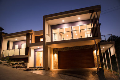 Cette image montre une grande façade de maison multicolore design à niveaux décalés avec un revêtement mixte et un toit plat.