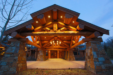 Cette photo montre une très grande façade de maison marron montagne en bois de plain-pied avec un toit à croupette.