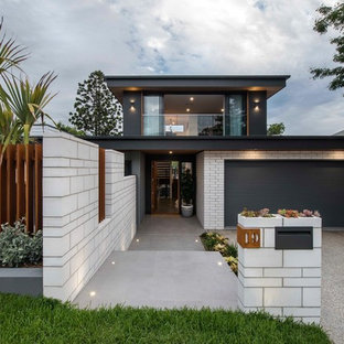 This is an example of a contemporary two-storey grey house exterior in Brisbane with mixed siding and a flat roof.