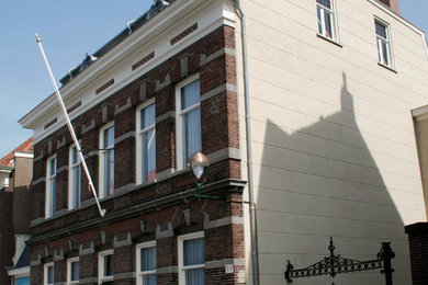 Foto de fachada clásica extra grande de tres plantas con revestimiento de ladrillo