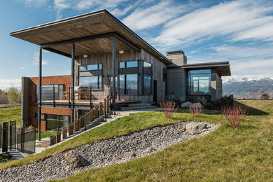 Example of a large mountain style two-story mixed siding exterior home design in Other with a shed roof