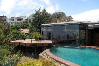 ロサンゼルスにある高級なミッドセンチュリースタイルのおしゃれな家の外観 (ガラスサイディング) の写真