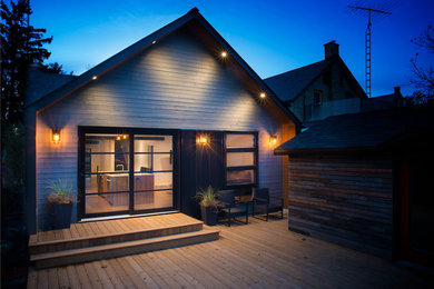 Diseño de fachada gris moderna de tamaño medio de dos plantas con revestimiento de madera y tejado a dos aguas