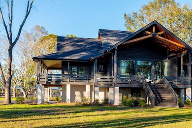 Example of a large beach style black one-story wood exterior home design in Charleston with a shingle roof