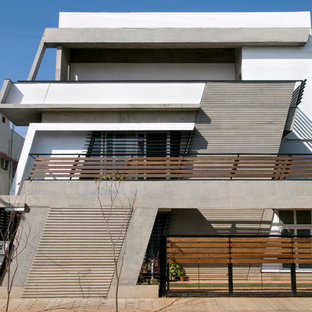 Foto della facciata di una casa ampia bianca contemporanea a tre piani con rivestimento in cemento