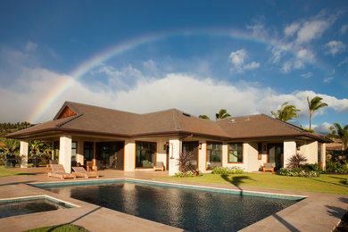 Example of a large trendy beige one-story stone exterior home design in Hawaii