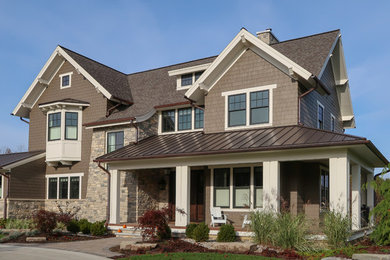 Inspiration for a large transitional two-story mixed siding house exterior remodel in Grand Rapids with a mixed material roof