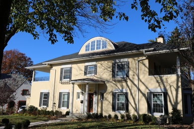 Large elegant beige two-story stucco house exterior photo in Kansas City with a hip roof and a shingle roof