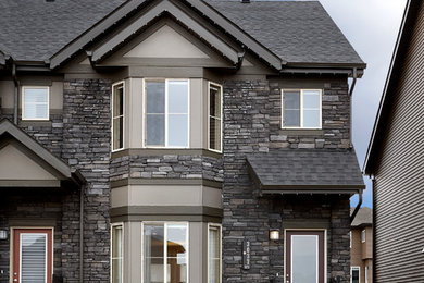 Mid-sized minimalist gray two-story stone gable roof photo in Edmonton