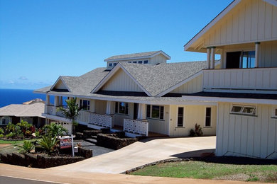 Example of a large beach style beige two-story wood exterior home design in Hawaii with a shingle roof