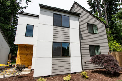 Imagen de fachada de casa gris moderna de tamaño medio de dos plantas con revestimiento de aglomerado de cemento y panel y listón