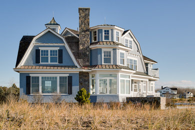 Immagine della facciata di una casa blu stile marinaro a tre piani con rivestimento in legno e tetto a mansarda