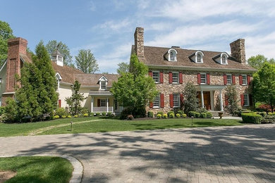 Huge three-story stone house exterior photo in New York with a shingle roof