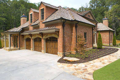 Large elegant red two-story brick house exterior photo in Atlanta with a hip roof and a shingle roof