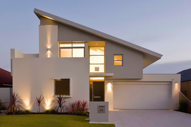 На фото: двухэтажный, серый дом в современном стиле с облицовкой из цементной штукатурки с