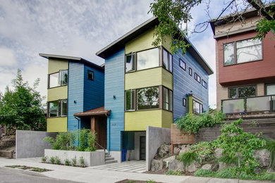 Foto della facciata di una casa blu moderna a tre piani con rivestimento con lastre in cemento