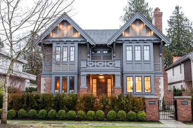 Large traditional brown two-story brick exterior home idea in Vancouver with a shingle roof