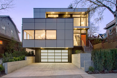 Example of a large trendy gray three-story metal flat roof design in Seattle