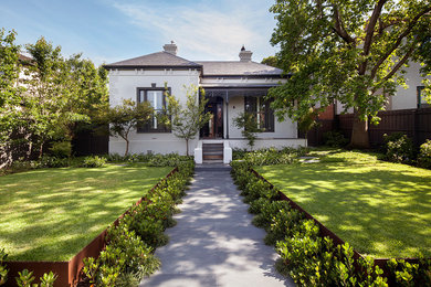 Photo of a white traditional bungalow house exterior in Melbourne with a hip roof.