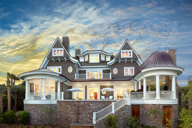 Immagine della facciata di una casa grande marrone classica a tre piani con rivestimento in legno