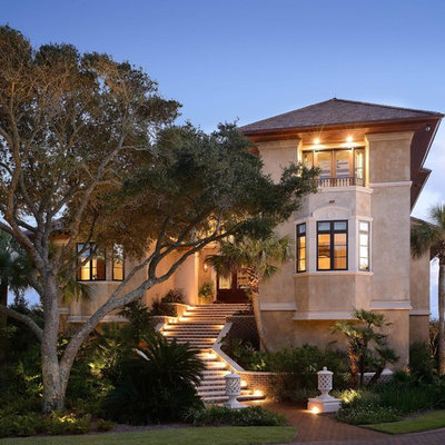 Large tuscan beige two-story stucco gable roof photo in Charleston