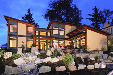 Imagen de fachada beige actual grande de dos plantas con revestimientos combinados y tejado plano