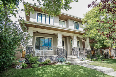 Large transitional white two-story stucco exterior home photo in Calgary