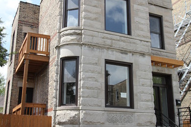 На фото: большой, трехэтажный, серый дом в классическом стиле с облицовкой из камня