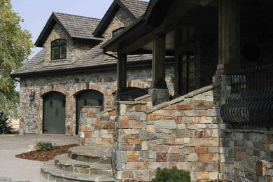 Inspiration for a huge farmhouse stone exterior home remodel in Other