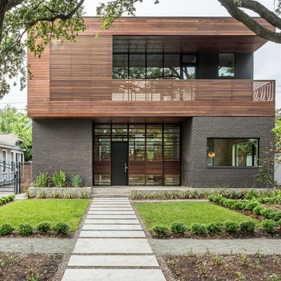 Inspiration for a large contemporary black two-story mixed siding flat roof remodel in Houston