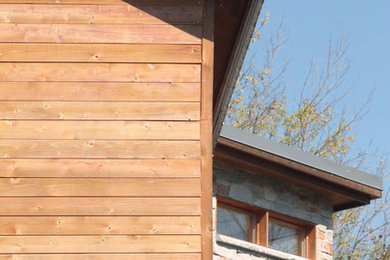 На фото: большой, двухэтажный, деревянный, коричневый частный загородный дом в современном стиле с двускатной крышей и металлической крышей