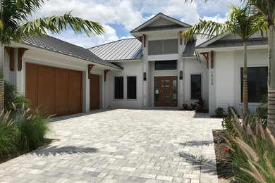 Large trendy white one-story concrete house exterior photo in Miami with a metal roof