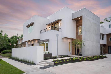 Imagen de fachada de casa blanca minimalista grande de dos plantas con revestimiento de hormigón y tejado plano