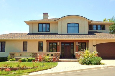 Imagen de fachada de casa beige contemporánea grande de dos plantas con revestimiento de estuco, tejado a dos aguas y tejado de teja de barro