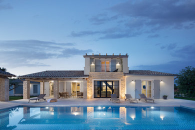 Modelo de fachada de casa beige mediterránea de tamaño medio con revestimientos combinados