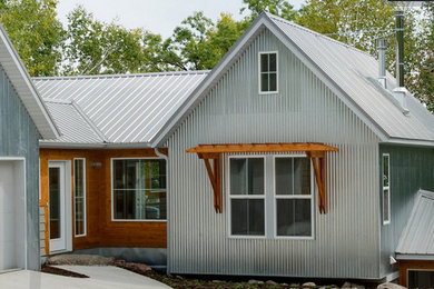 Inspiration for a large modern gray three-story mixed siding gable roof remodel in Other