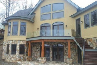 Foto de fachada de casa beige de estilo americano de tamaño medio de dos plantas con revestimientos combinados, tejado a cuatro aguas y tejado de teja de madera