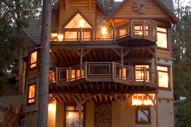 На фото: большой, трехэтажный, коричневый частный загородный дом в стиле рустика с комбинированной облицовкой, двускатной крышей и крышей из гибкой черепицы