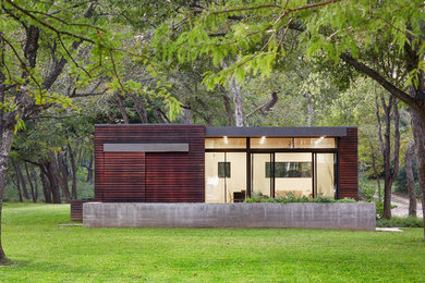 Diseño de fachada de casa pequeña de una planta con revestimiento de madera y tejado plano