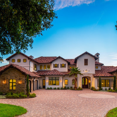 Example of a large tuscan white two-story stone exterior home design in Austin with a tile roof