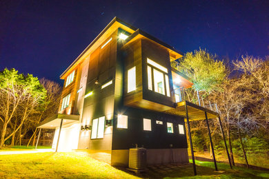 Example of a large minimalist white three-story concrete fiberboard house exterior design in Austin with a shed roof and a metal roof